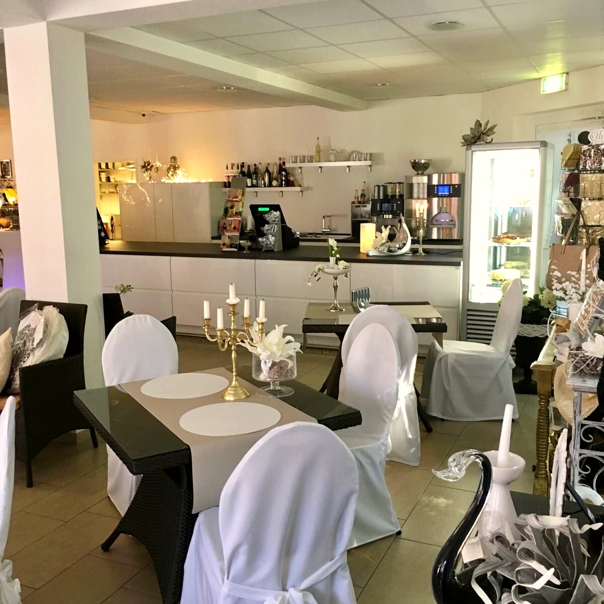 Cafébereich mit Theke, Sitzgruppen und festlicher Tischdekoration