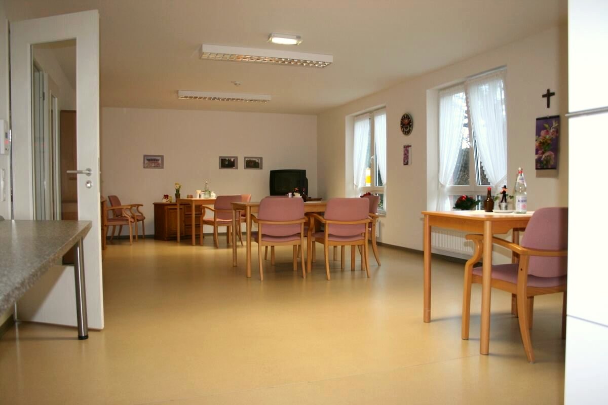 Heller Aufenthaltsraum mit Tischen, Stühlen und großen Fenstern im Seniorenzentrum Wehebachtal