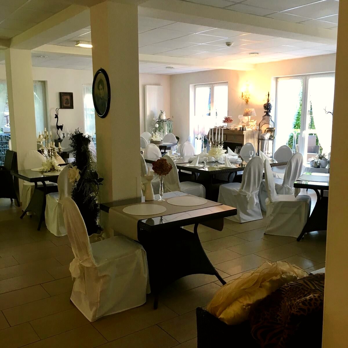 Heller Speisesaal mit eingedeckten Tischen und großen Fensterfronten